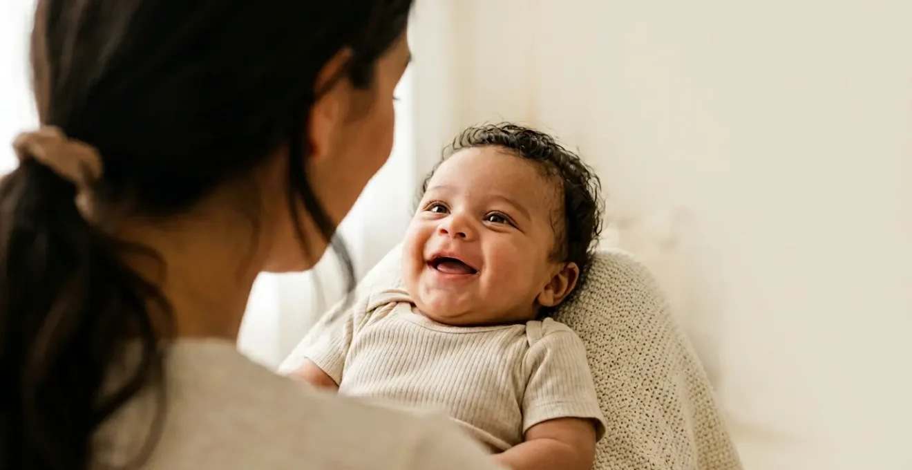 Close-up photograph of a 6-week-old baby making eye contact and smiling at parent during face-to-face interaction