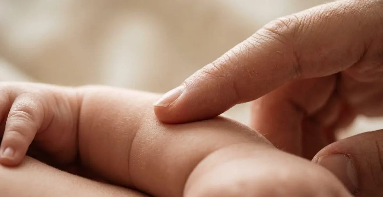 Close-up of gentle caregiving touch building infant-parent neural connection