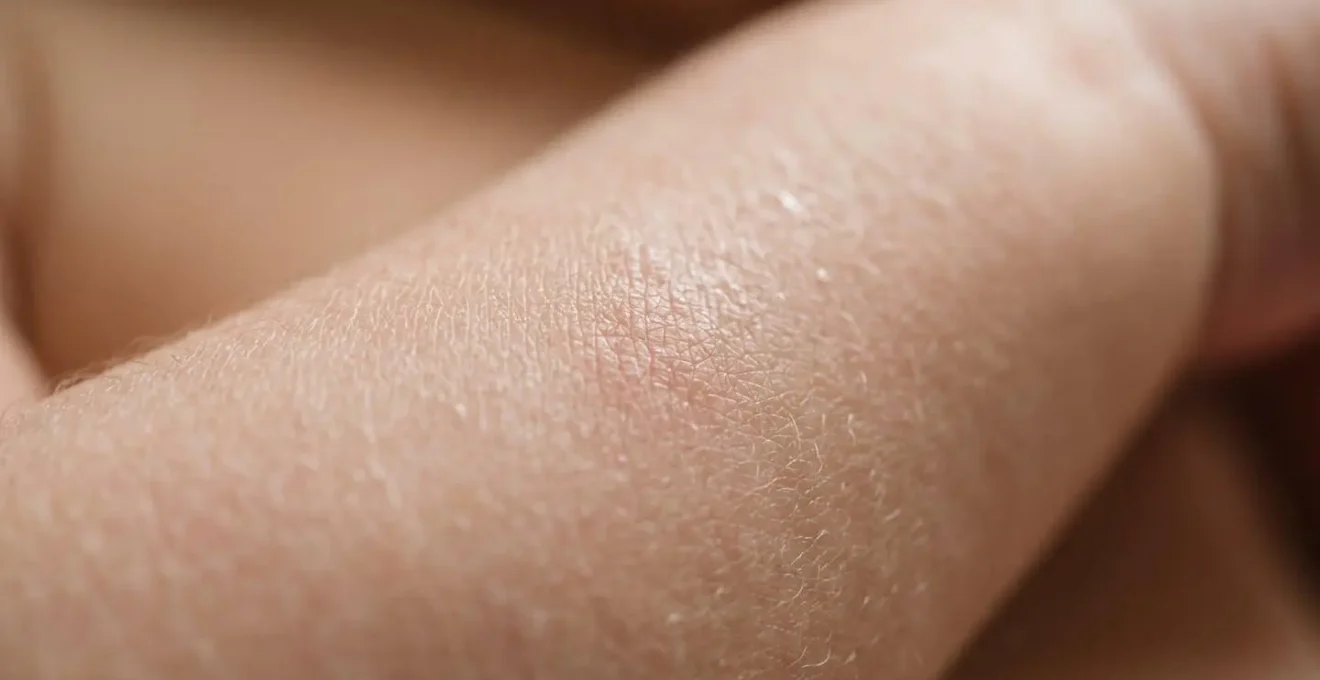 Extreme macro close-up photograph of delicate newborn skin texture showing fine natural surface details with shallow depth of field