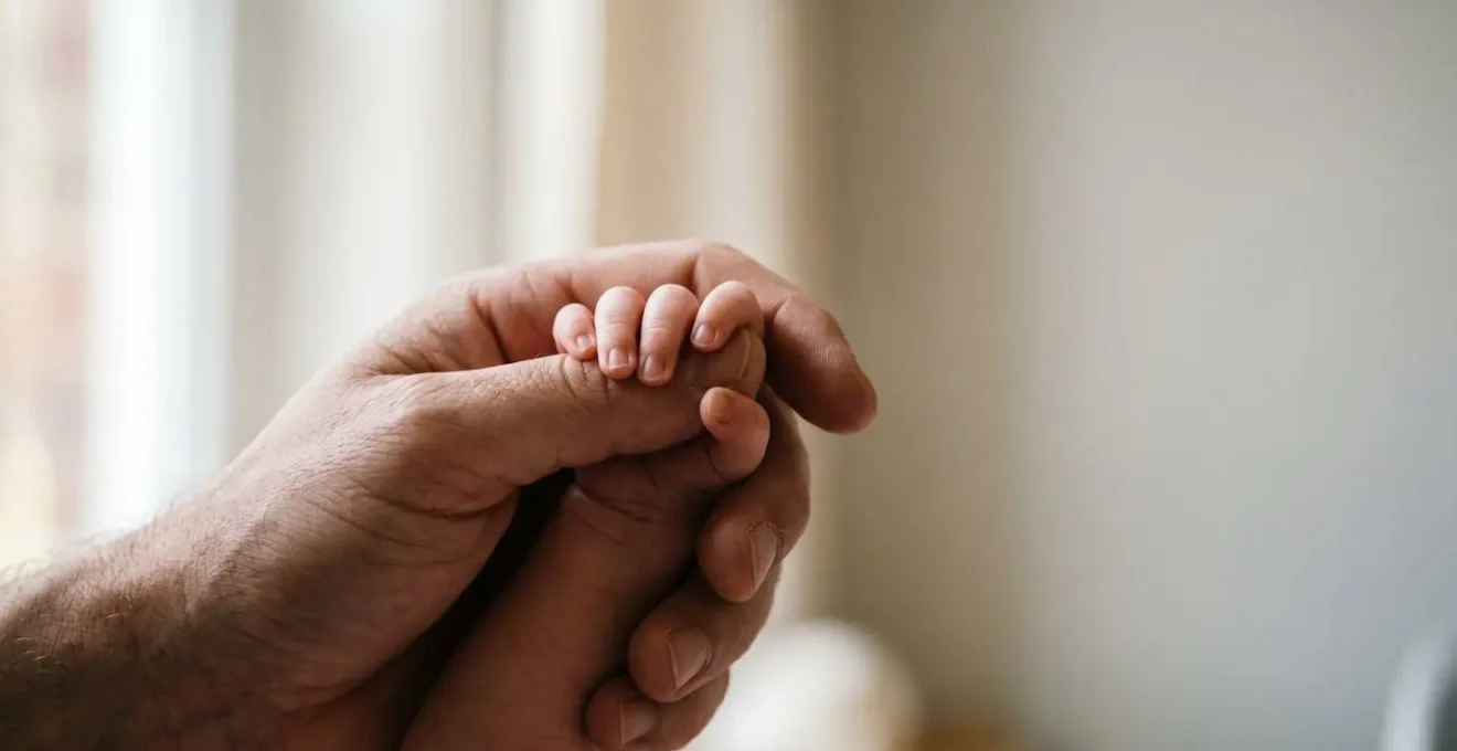 Intimate close-up of parent and newborn hands gently touching representing safe daytime contact and bonding